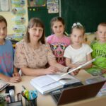teacher helping student in classroom