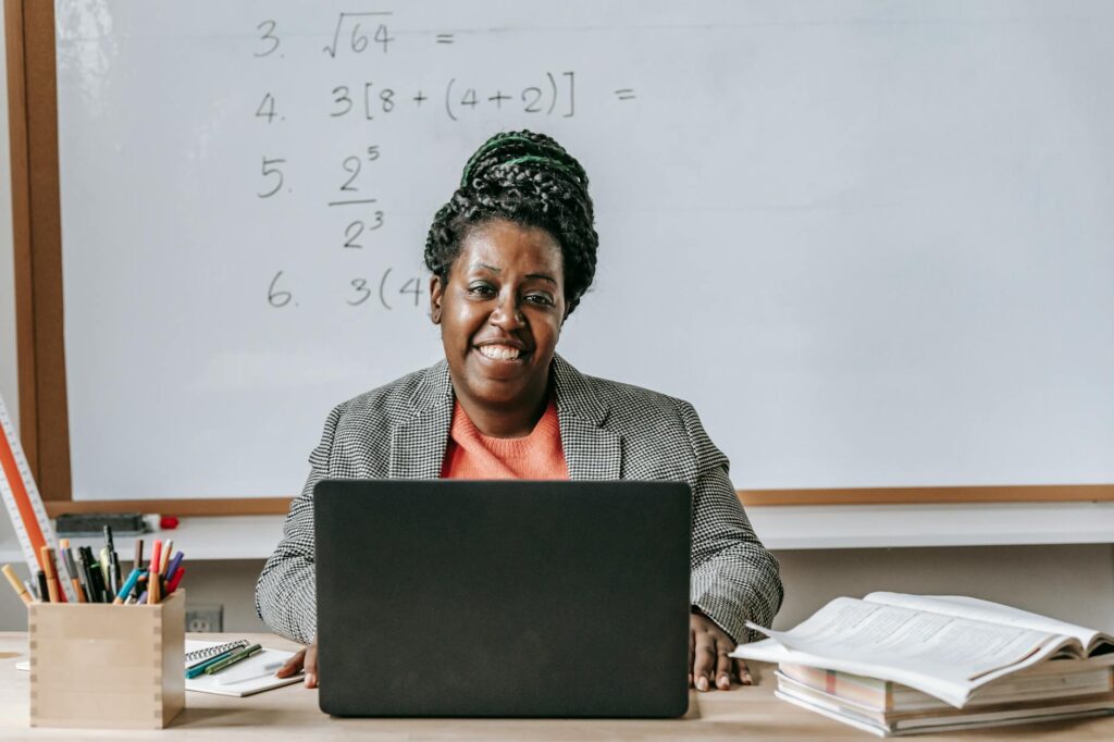 teacher using laptop in classroom