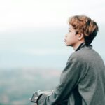 teenager looking at phone with stock chart